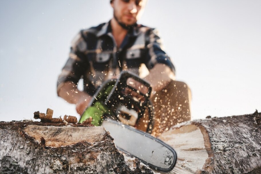 Man at work cutting wood with a chainsaw