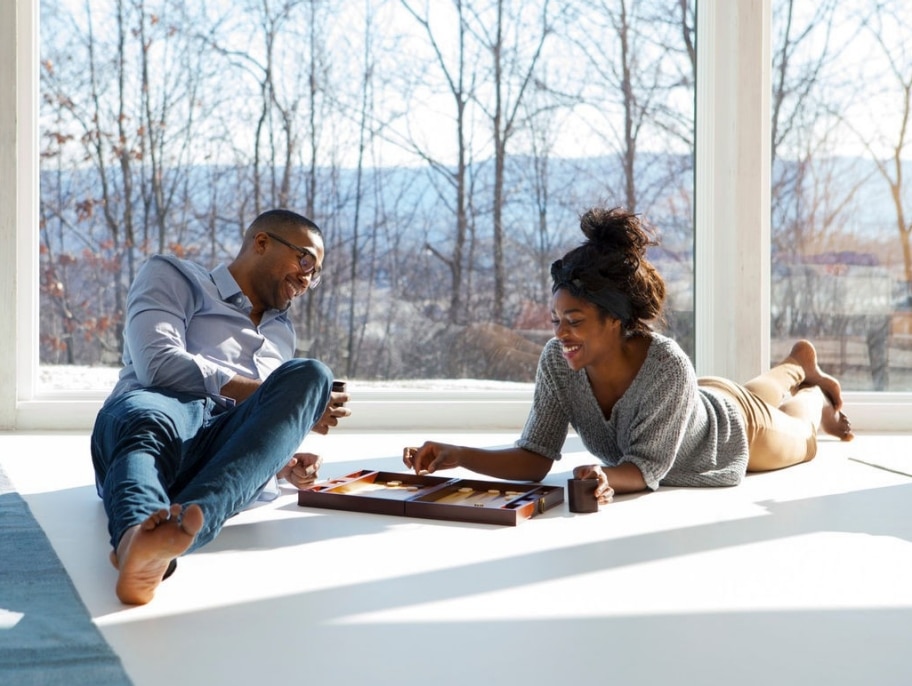Una pareja jugando a un juego de mesa en el suelo