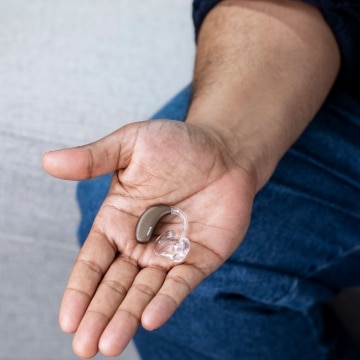 Audífono en la palma de la mano de un hombre