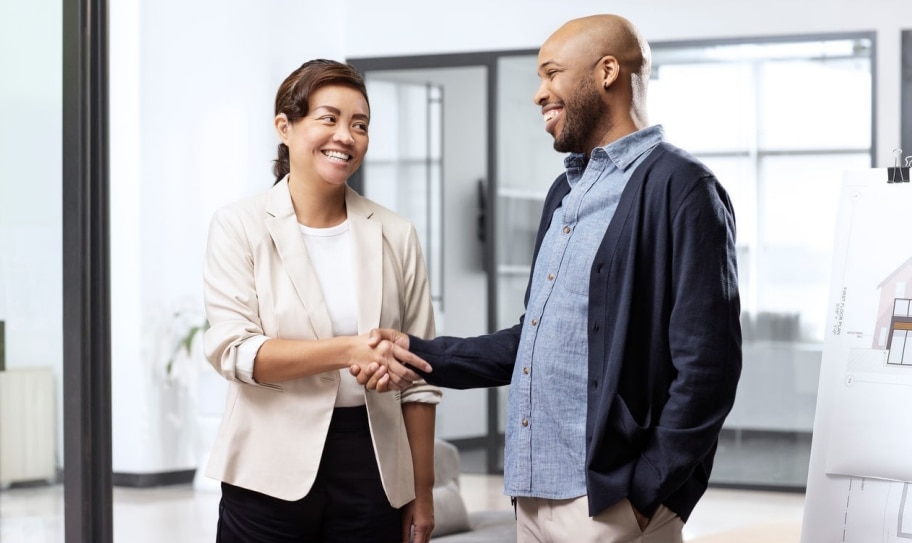 Compañeros dándose la mano en una oficina.